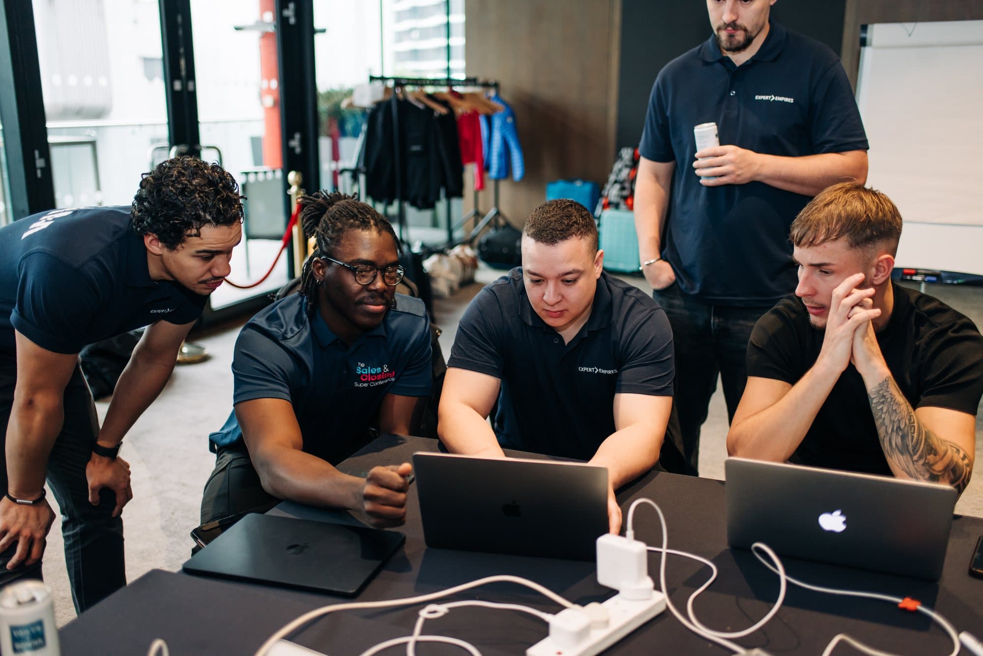 Jossiah at a live event, working on his laptop while colleagues look on